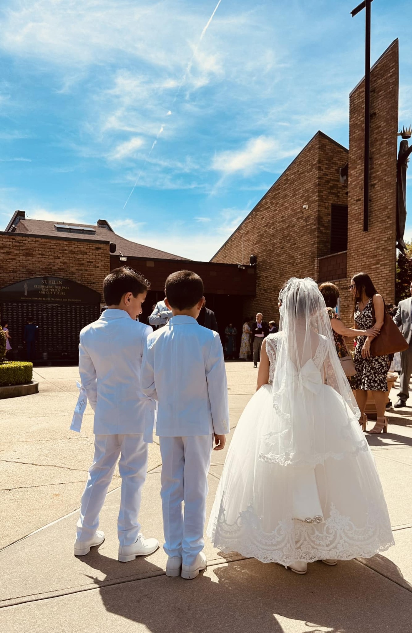 boys in suits and girl in gown for first communion